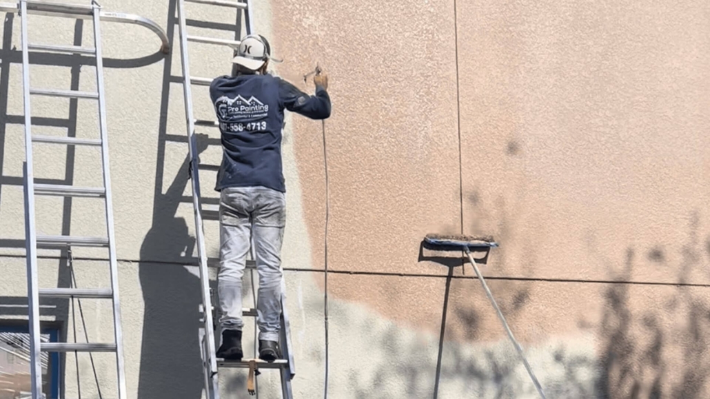 A picture of a guy working in a exterior painting